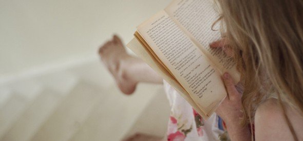 Little girl reading a book. Teaching children to read.